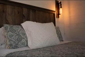 a bed with a white pillow on top of it at The Lupine | Cross Stone Cabins • Walk to Rangeley Lake in Rangeley