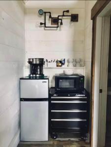 a small kitchen with a microwave and a stove at The Lupine | Cross Stone Cabins • Walk to Rangeley Lake in Rangeley