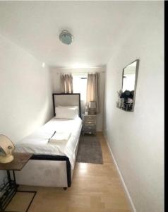 a bedroom with a bed and a desk and a mirror at Pendleton in Peterborough