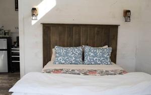 a bed with two blue pillows and a wooden headboard at The Ridgeline | Near Saddleback • Walk to Rangeley Lake in Rangeley