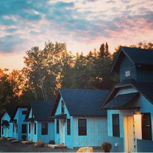 a row of houses with the sunset in the background at The Ridgeline | Near Saddleback • Walk to Rangeley Lake in Rangeley