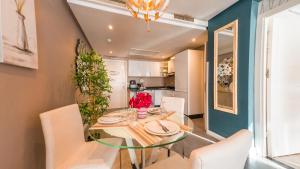 a dining room with a glass table and white chairs at RENT-INN Suites Hotel in Rabat