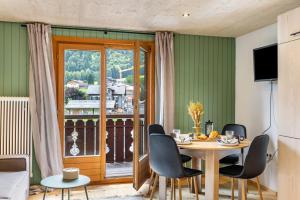 a dining room with a table and chairs and a balcony at Haus Helena Sophia in Au