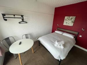 a bedroom with a white bed and a white table at Harbour Stays in Skegness