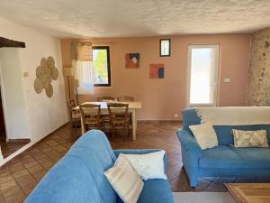 a living room with a blue couch and a table at Bastide du Buou in Puyvert