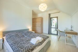 a bedroom with a bed and a desk and a table and chair at Luxusní vila Serenity 15 min od Prahy in Beroun +92 photos