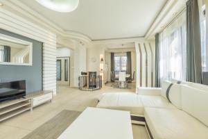 a living room with a white couch and a tv at Luxusní vila Serenity 15 min od Prahy in Beroun