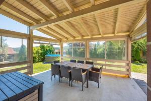 a screened in porch with a table and chairs at Luxusní vila Serenity 15 min od Prahy in Beroun