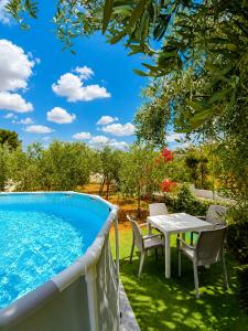 a patio with a table and chairs next to a swimming pool at Villa Mele in Lido Marini
