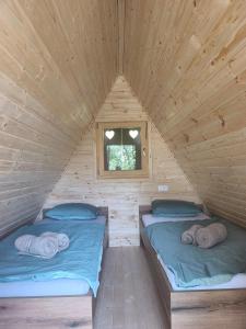 two beds in a wooden room with a window at Pr' Končovc - wooden tent in Kranj +5 photos