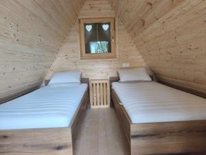 two beds in a wooden room with a window at Pr' Končovc - wooden tent in Kranj