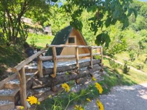 a small dog house with a fence and flowers at Pr' Končovc - wooden tent in Kranj