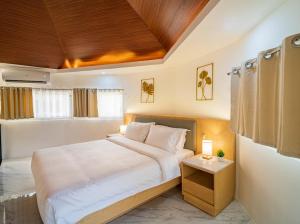 ein Schlafzimmer mit einem großen Bett und einer Holzdecke in der Unterkunft Fizz Diving Resort in Panglao + 43 Fotos