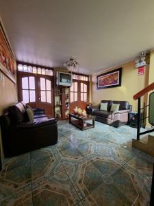 a large living room with couches and a tv at Hotel La Reserva INN in Ayacucho