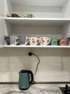 a shelf with coffee cups and a kettle on it at Hostel Velvet Vouge in Yerevan