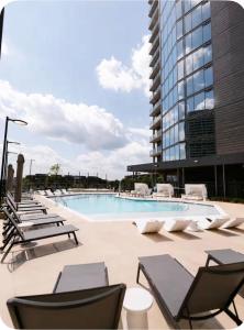 a swimming pool with lounge chairs and a building at Atl oasis in Atlanta
