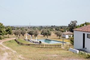 a swimming pool in a field next to a building at Quinta Dos Ribeiros in Alpalhão