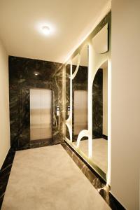 a bathroom with a walk in shower and a mirror at Inzhu Premium Hotel in Taraz +217 photos