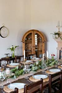 a dining room with a table with glasses and a clock at Quinta Dos Ribeiros in Alpalhão