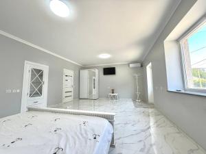 a large white room with a bed and a window at Apartment HOME две спальни in Reni