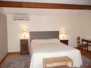 a bedroom with a white bed and a table at Galot La Chapelle in Gardegan-et-Tourtirac