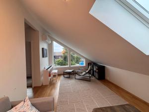 an attic living room with a large window at Cozy Scandinavian Retreat in Sola
