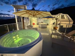 a bath tub on a boat with an umbrella at Chalé A-Frame - Chalé de Cima in Ouro Preto