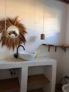 a bathroom with a sink and a mirror on a counter at Mambo Leo Hostel in Paje