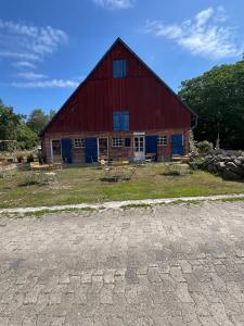 a red barn with picnic tables in front of it at Große Auszeit im Tiny House in Schashagen