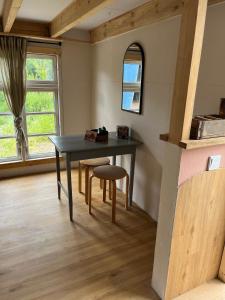 a dining room with a table and a chair at Große Auszeit im Tiny House in Schashagen +2 photos