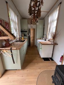 a kitchen with wooden floors and white counter tops at Große Auszeit im Tiny House in Schashagen