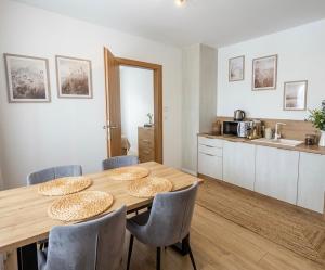 a dining room with a table and chairs and a kitchen at Askana in Białka Tatrzańska