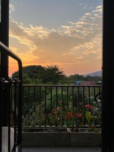 a balcony with a view of a garden with flowers at LECAR Home Shelby in Ban Nong Khang +4 photos
