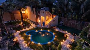an overhead view of a backyard with a swimming pool with lights at Mezorin Farm & Hot Spring - Peaceful Eco-Retreat & Private Stay in Siwa