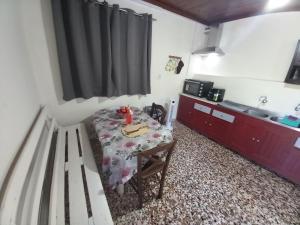 a small room with a table and a kitchen at Belvedere di Van D'oro 1886 in Peroulades