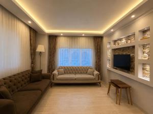 a living room with a couch and a television at Pasha Residence in Trabzon