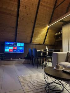 a dining room with tables and chairs and a tv at LiLo s Villa in Ferizaj