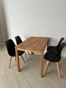 a wooden table with four black chairs around it at Ferienwohnung Zweinig 06 in Zweinig +6 photos