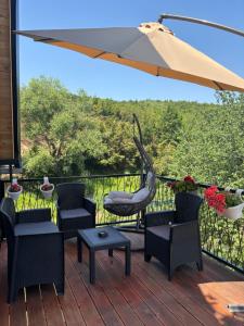 a patio with chairs and an umbrella on a deck at LiLo s Villa in Ferizaj +14 photos