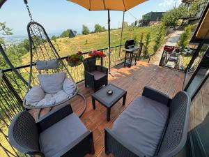 a patio with chairs and a swing and an umbrella at LiLo s Villa in Ferizaj