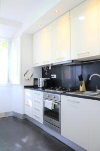 a kitchen with white cabinets and a stove at Charming Duplex- Príncipe Real in Lisbon