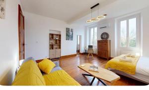 a living room with a bed and a yellow couch at Authentic Residence from 1792 - Caujac in Caujac