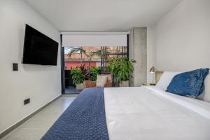 a bedroom with a large bed and a flat screen tv at Park 38 in Envigado