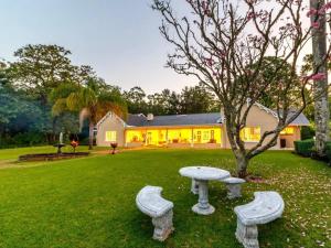 a table and two benches in a yard at Blue Mountain Estate in Hazyview