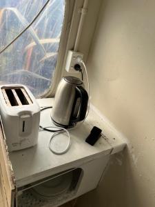 a coffee maker and a toaster sitting on a shelf next to a window at Akerama farm stay in Hukerenui