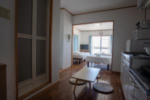 a room with a kitchen and a room with two beds at Hotel Sunset ZANPA in Yomitan