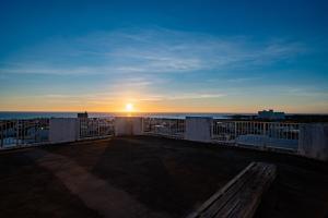 a view of the sunset from a balcony with a bench at Hotel Sunset ZANPA in Yomitan