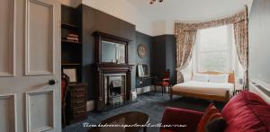 a room with a bedroom with a bed and a fireplace at The Priory House in Tynemouth