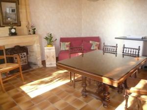 a living room with a table and a fireplace at Galot La Chapelle in Gardegan-et-Tourtirac +15 photos