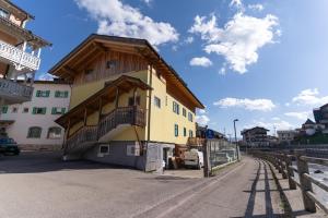 a building with a wooden roof on a street at Rossetti Big by AMA Val di Fassa in Pozza di Fassa +6 photos